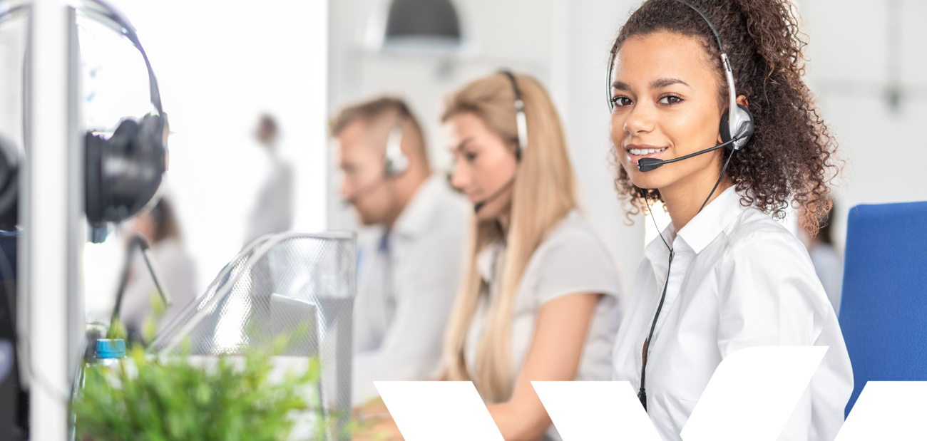 A row of people wearing headsets taking customer calls