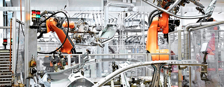 Orange robots building cars