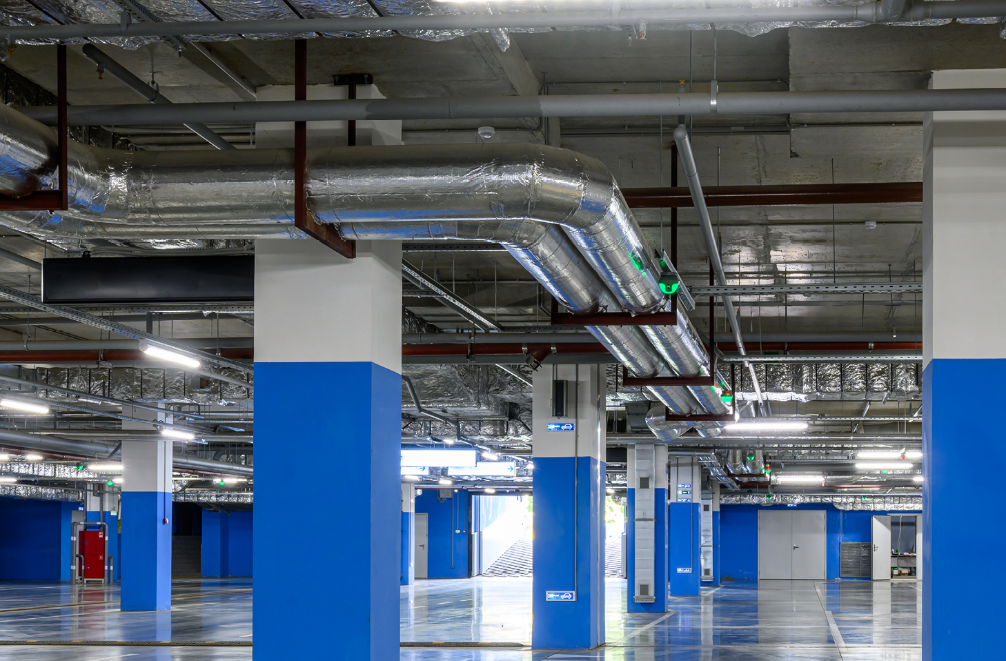 A stock photo showing lots of ducting in an underground car park