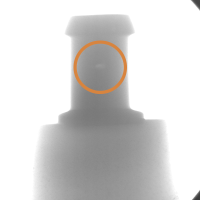 An x ray of an impeller blade with a an orange circle highlighting an imperfection