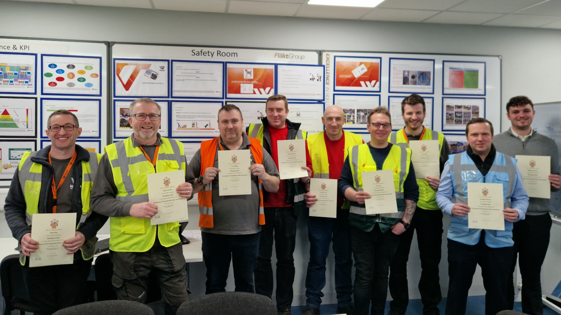A photo of nine Woods employees with their certificates