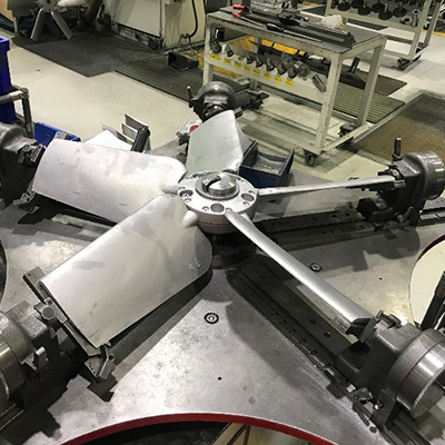 A 5 bladed impeller held down by five brackets on a work bench